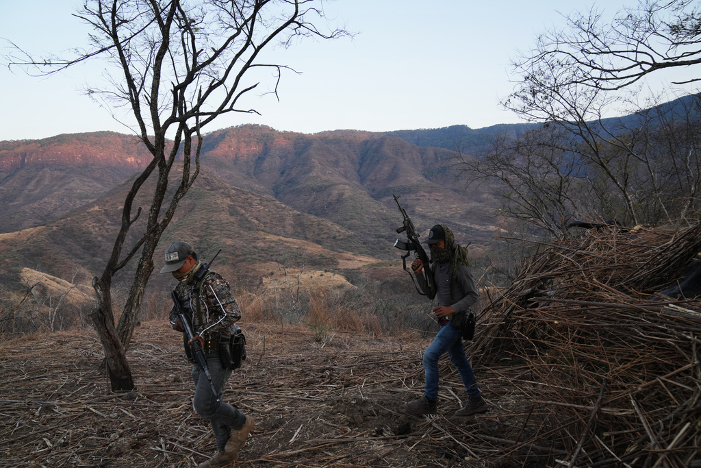 Members of a local self-defense group formed by residents in response to cartel violence stand guard in Guajes de Ayala, Mexico, Tuesday, March 10, 2026. (AP Photo/Marco Ugarte)