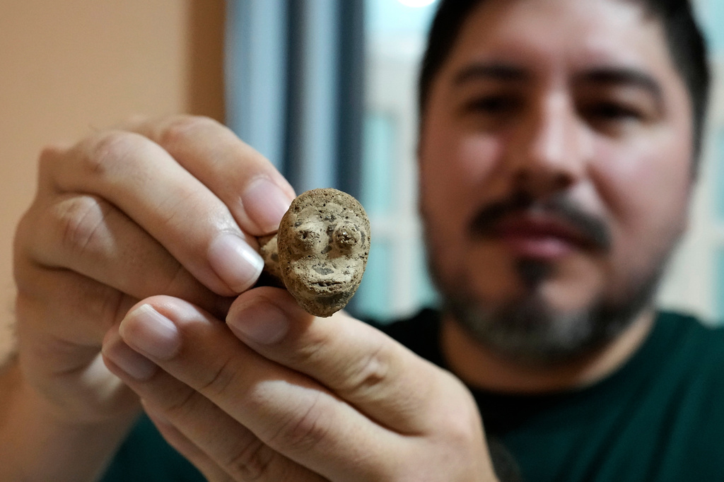 Archaeologist Manoel Fabiano da Silva Santos shows an anthropomorphic artifact found at the Quintela archaeological site at the National Department of Transport Infrastructure in Macapa, Amapa state, Brazil, Saturday, March 14, 2026. (AP Photo/Eraldo Peres)