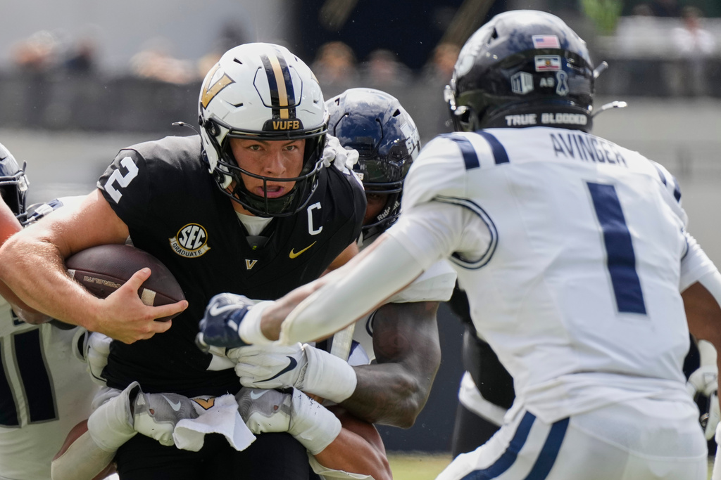 Vanderbilt quarterback Diego Pavia (2) runs the ball against Utah State cornerback Noah Avinger (1) during the first half of an NCAA college football game Saturday, Sept. 27, 2025, in Nashville, Tenn. (AP Photo/George Walker IV)