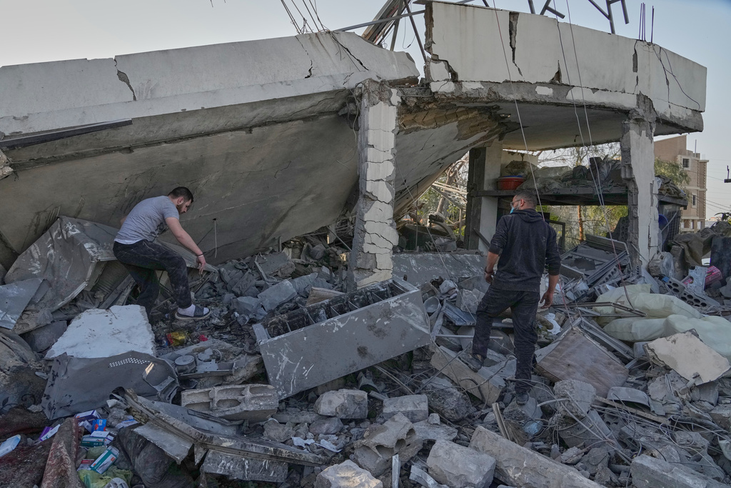 People check a house where multiple family members were killed by an Israeli airstrike, in Erkay village, south Lebanon, Thursday, March 12, 2026. (AP Photo/Mohammed Zaatari)