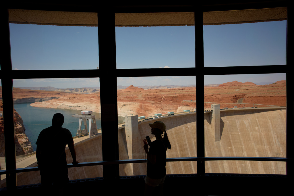 People look at the Glen Canyon Dam, Tuesday, July 14, 2026, near Page, Nev. (AP Photo/John Locher)