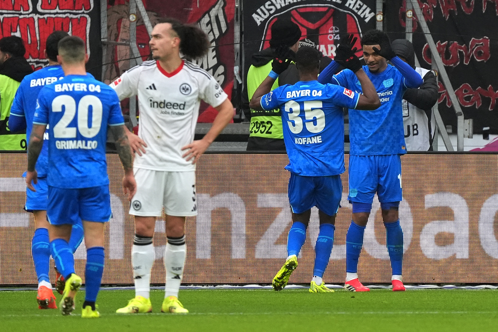 Leverkusen's Malik Tillmann, right, celebrates after scoring his side's second goal during the German Bundesliga soccer match between Eintracht Frankfurt and Bayer 04 Leverkusen in Frankfurt, Germany, Saturday, Jan. 31, 2026 (Marc Schueler/dpa via AP)