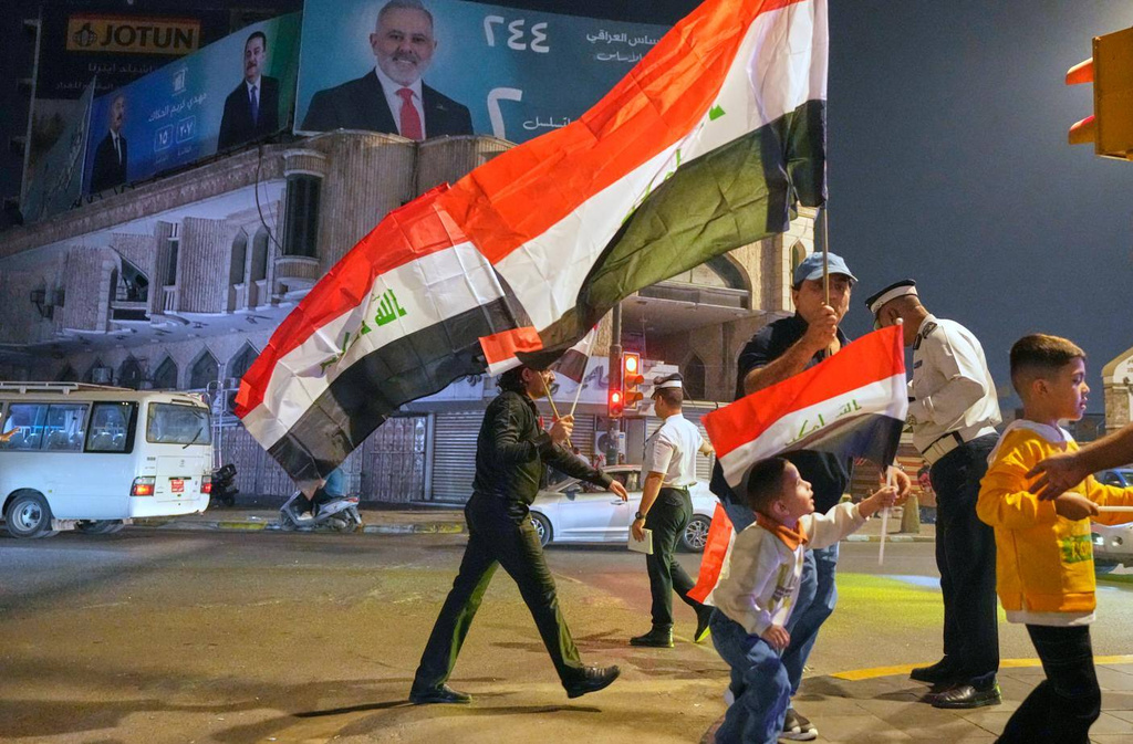 Supporters of Iraqi Prime Minister Mohammed Shia al-Sudani cheer in Tahrir Square, Baghdad, Iraq, Wednesday, Nov. 12, 2025, after results showed al-Sudani's bloc won the largest amount of seats in the parliamentary election. (AP Photo/Hadi Mizban)