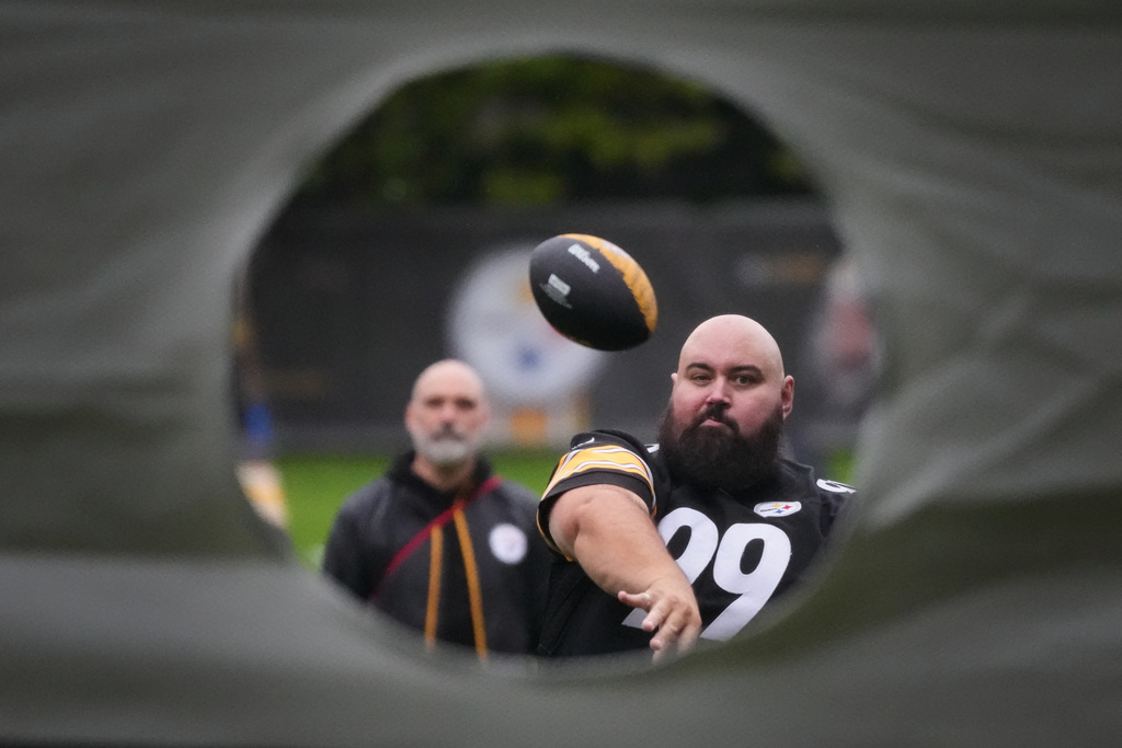 A football supporter throws a ball at the Steelers Tailgate event at Merrion Square ahead of the NFL football match between Minnesota Vikings and Pittsburgh Steelers in Dublin, Saturday, Sept. 27, 2025.(AP Photo/Frank Augstein)
