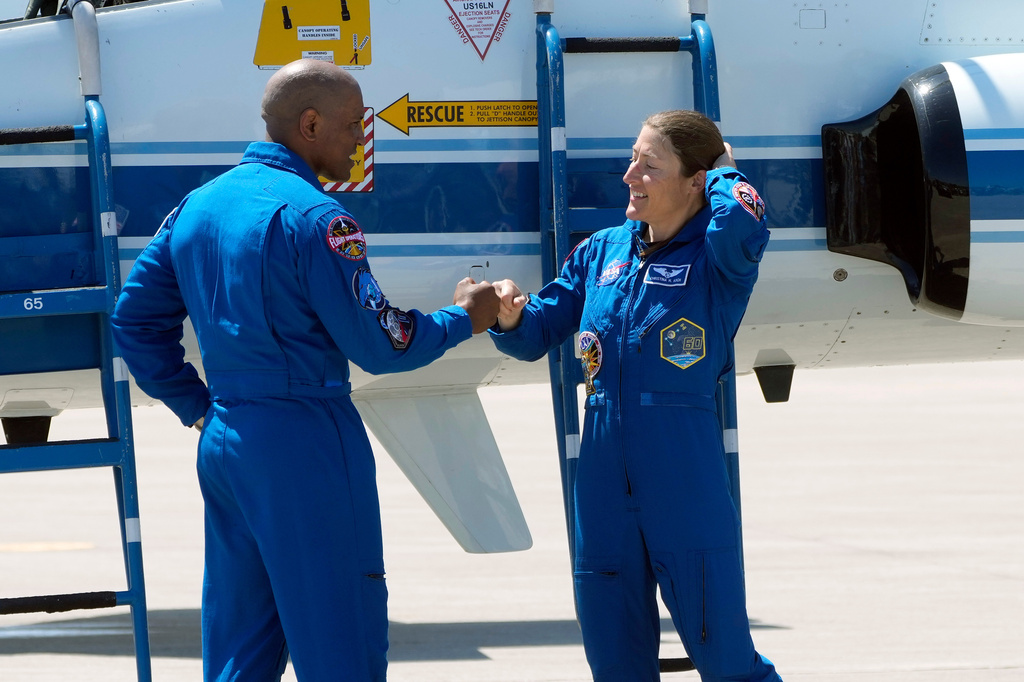 Artemis 2 crew members, pilot Victor Glover, left, and Mission Specialist Christina Koch, fist bump after the crew's arrival at the Kennedy Space Center Friday, March 27, 2026, in Cape Canaveral, Fla. (AP Photo/Chris O'Meara)