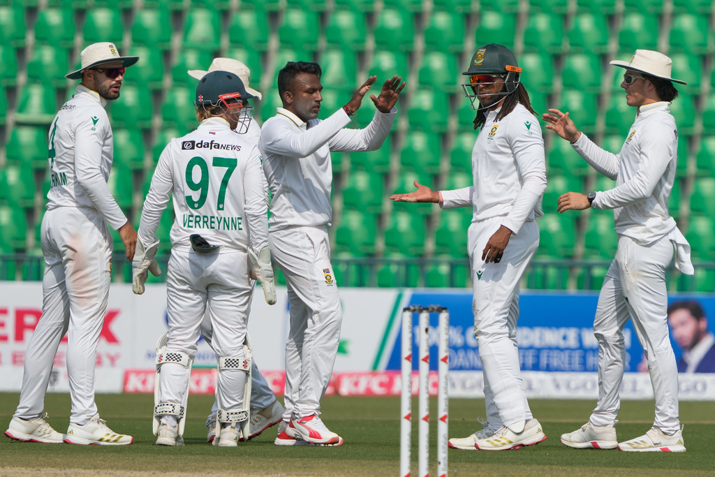 South Africa's Senuran Muthusamy, center, celebrates with teammates after taking the wicket of Pakistan's Abdullah Shafique during the third day of the first test cricket match between Pakistan and South Africa, in Lahore, Pakistan, Tuesday, Oct. 14, 2025. (AP Photo/K.M. Chaudary)