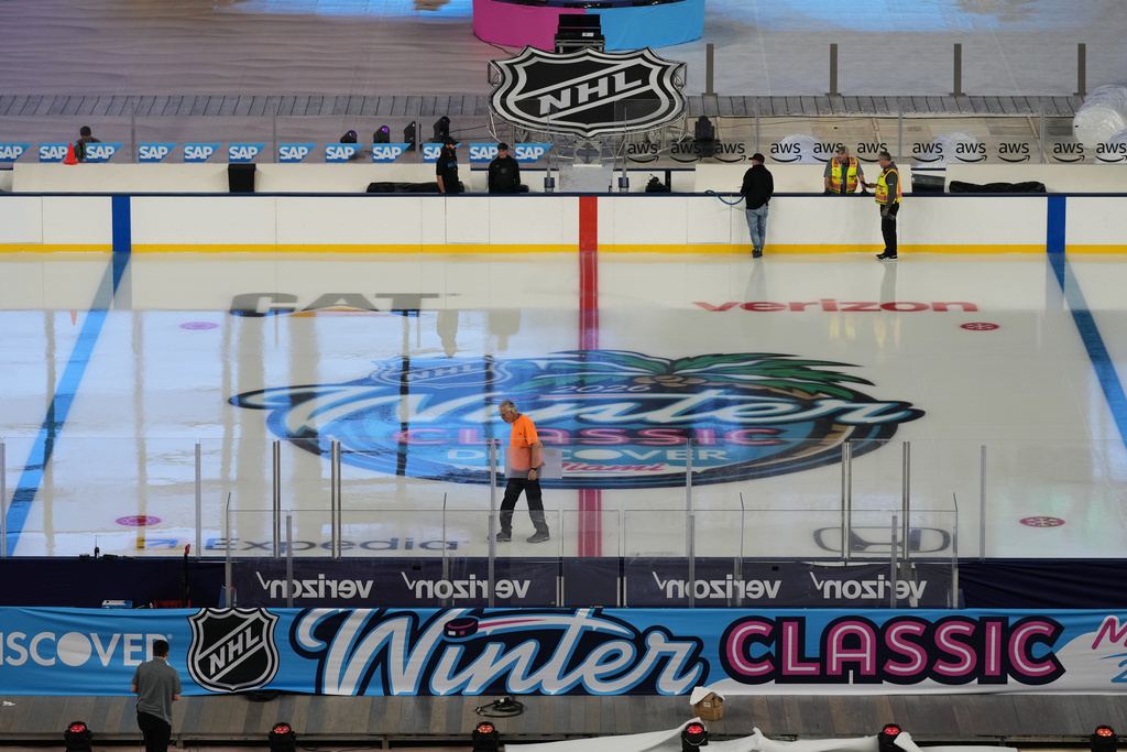 Workers prepare the ice for the upcoming NHL Winter Classic hockey game between the Florida Panthers and New York Rangers, Tuesday, Dec. 30, 2025, at loanDepot Park in Miami. (AP Photo/Lynne Sladky)