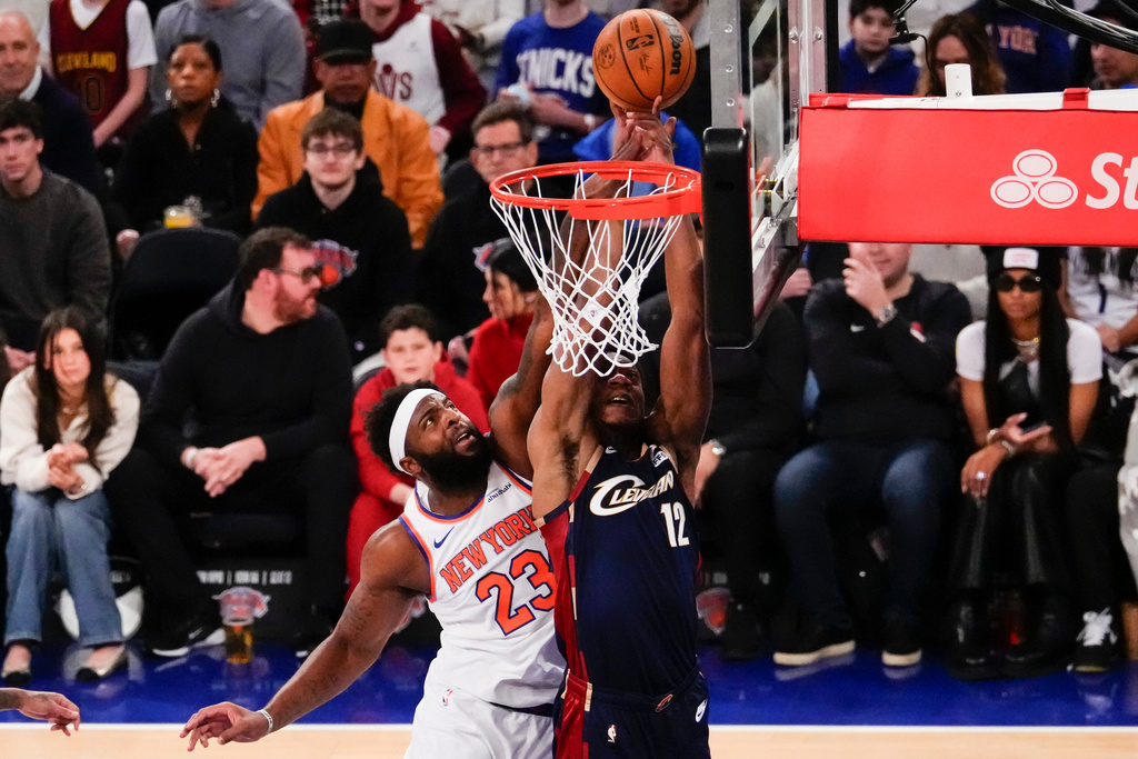 New York Knicks center Mitchell Robinson (23) blocks Cleveland Cavaliers forward De'Andre Hunter (12) during the first half of an NBA basketball game, Thursday, Dec. 25, 2025, in New York. (AP Photo/Yuki Iwamura)