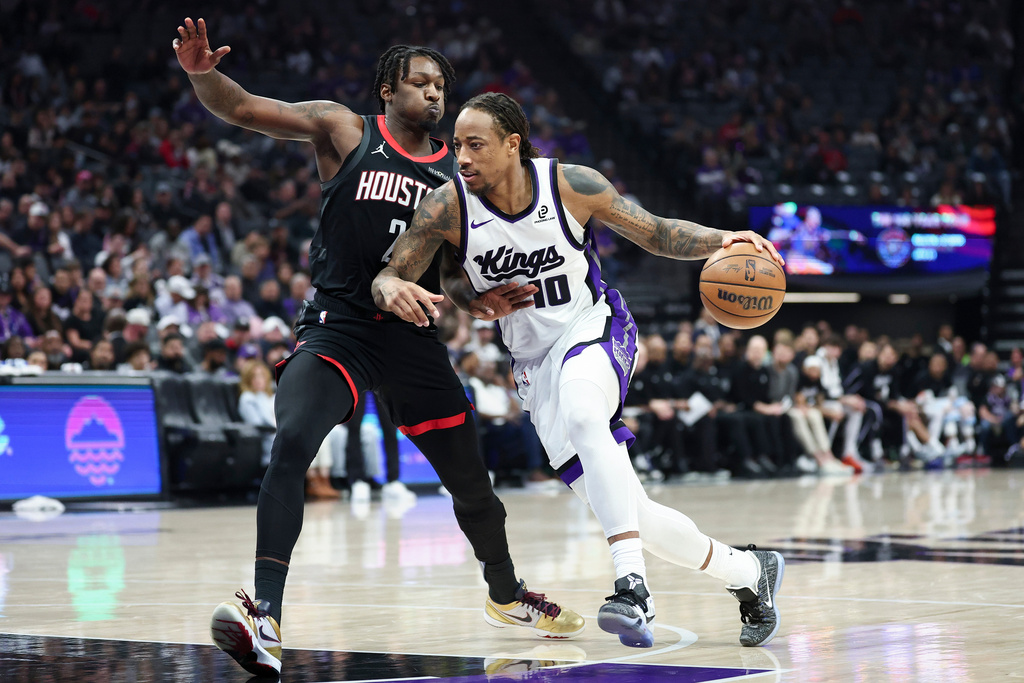 Sacramento Kings guard DeMar DeRozan (10) drives to the basket with Houston Rockets forward Dorian Finney-Smith, left, defending during the first half of an NBA basketball game, Sunday, Jan. 11, 2026, in Sacramento, Calif. (AP Photo/Sara Nevis)