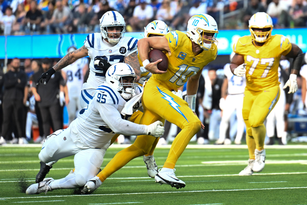Indianapolis Colts defensive tackle Adetomiwa Adebawore (95) tackles Los Angeles Chargers quarterback Justin Herbert (10) during the second half of an NFL football game Sunday, Oct. 19, 2025, in Inglewood, Calif. (AP Photo/Carrie Giordano)