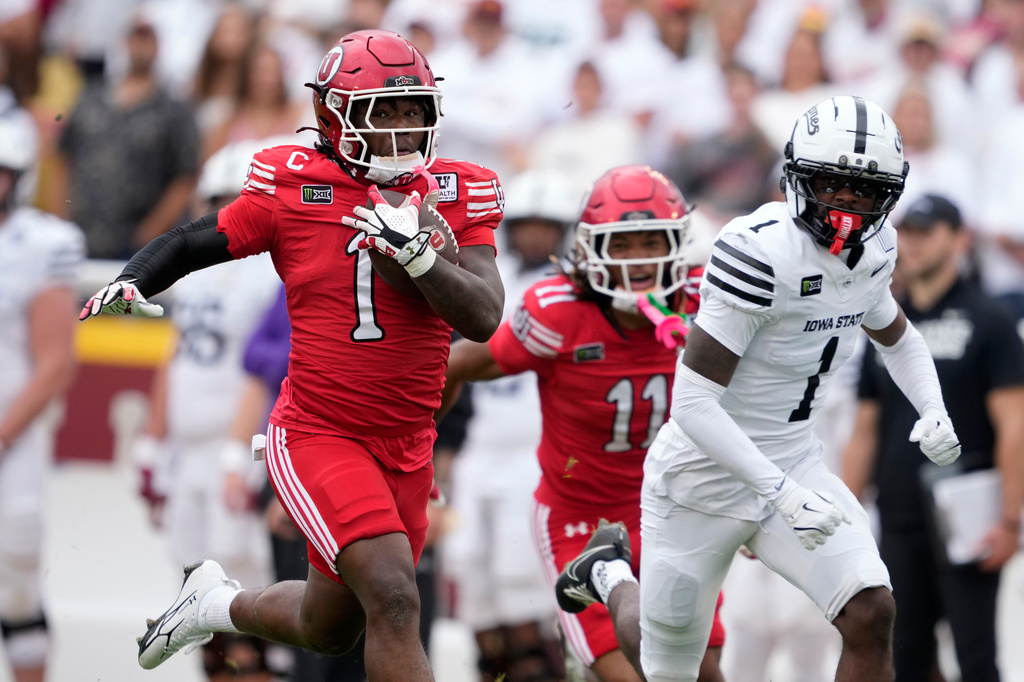 Utah running back Wayshawn Parker, left, runs from Iowa State cornerback Keyon Washington, right, during a touchdown run in the first half of an NCAA college football game, Saturday, Sept. 26, 2026, in Ames, Iowa. (AP Photo/Charlie Neibergall)