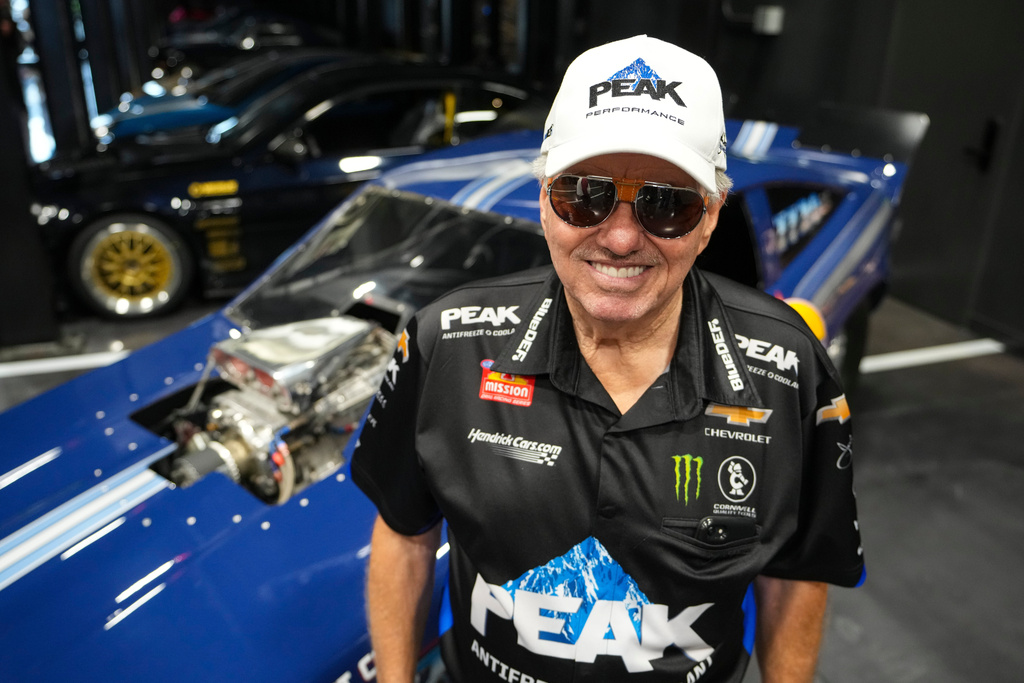 FILE - Drag racing car owner John Force poses next to his original funny car, Aug. 28, 2025, in Zionsville, Ind. (AP Photo/Michael Conroy, File)
