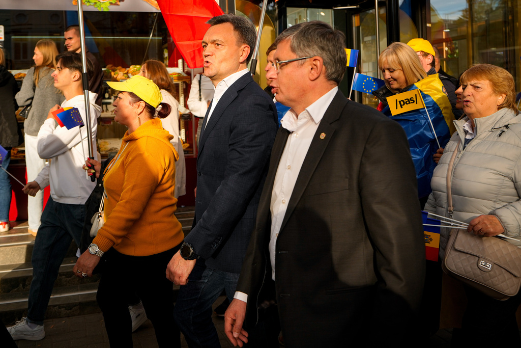 Moldova's Prime Minister Dorin Recean, center left, walks with Igor Grosu, the president of the ruling Party of Action and Solidarity, right, during a pro-EU rally of the ruling Party of Action and Solidarity (PAS), in Chisinau, Moldova, Friday, Sept. 26, 2025, ahead of parliamentary elections taking place on Sept. 28. (AP Photo/Vadim Ghirda)