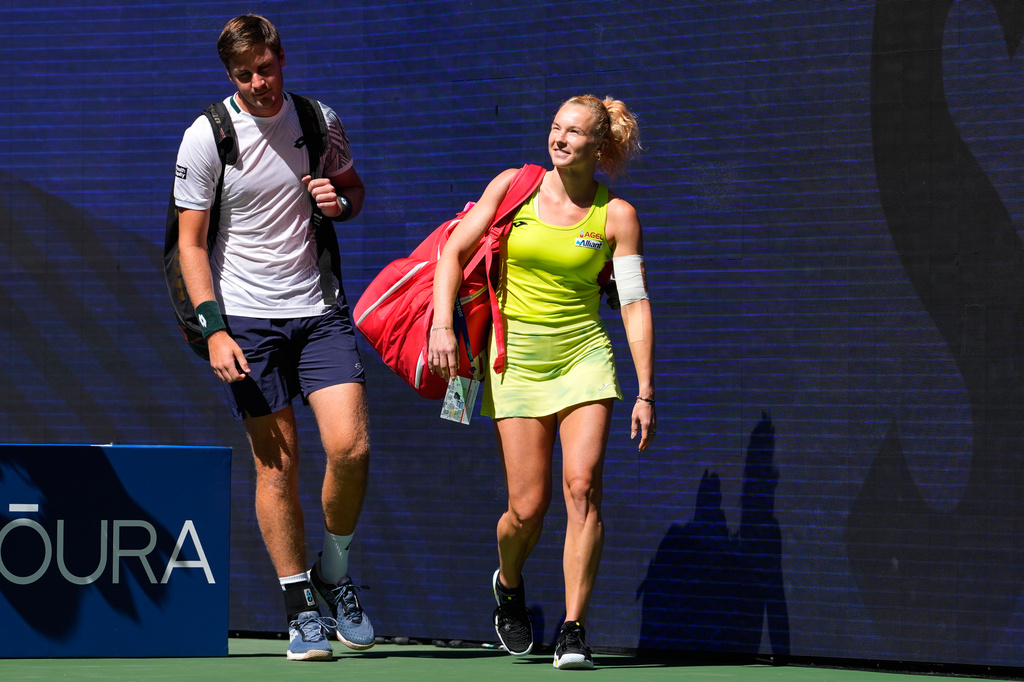 Henry Patten, of Britain, left, and Katerina Siniakova, of the Czech Republic, arrive on the court ahead of a mixed doubles match at the U.S. Open tennis championships, Tuesday, Aug. 25, 2026, in New York. (AP Photo/Yuki Iwamura)