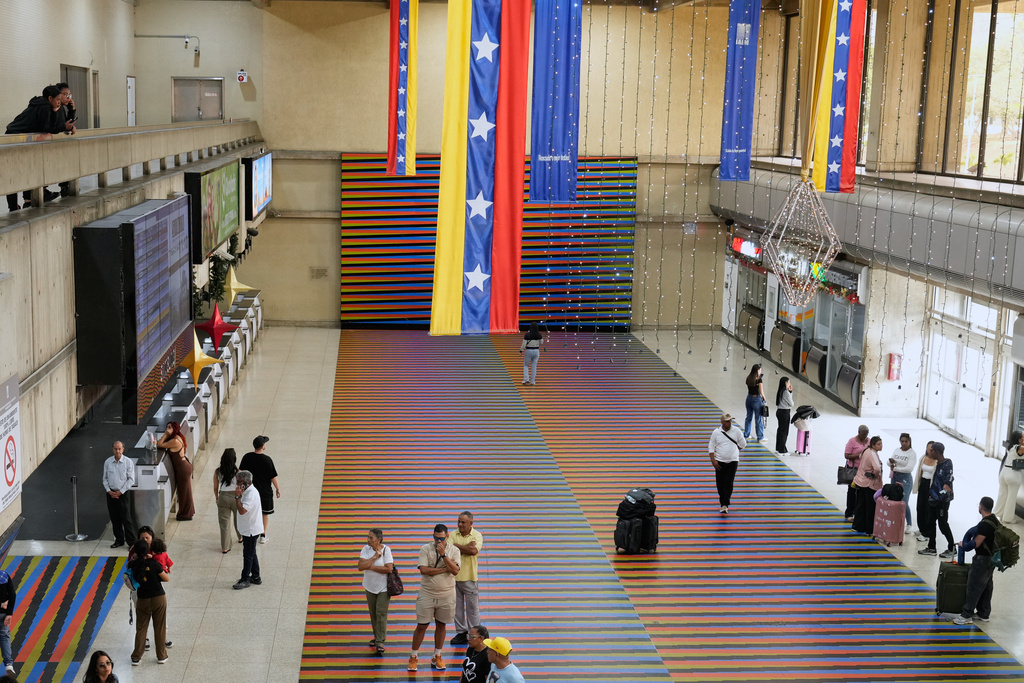 Travelers wait in the main hall of the Simon Bolivar Maiquetia International Airport in Maiquetia, Venezuela, Sunday, Nov. 23, 2025, after several international airlines canceled flights following a warning from the U.S. Federal Aviation Administration about a hazardous situation in Venezuelan airspace. (AP Photo/Ariana Cubillos)