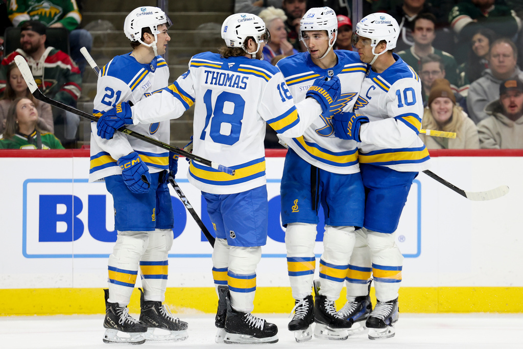 The St. Louis Blues congratulate defenseman Logan Mailloux (23) on his goal during the second period of an NHL hockey game against the Minnesota Wild Sunday, March 1, 2026, in St. Paul, Minn. (AP Photo/Ellen Schmidt)
