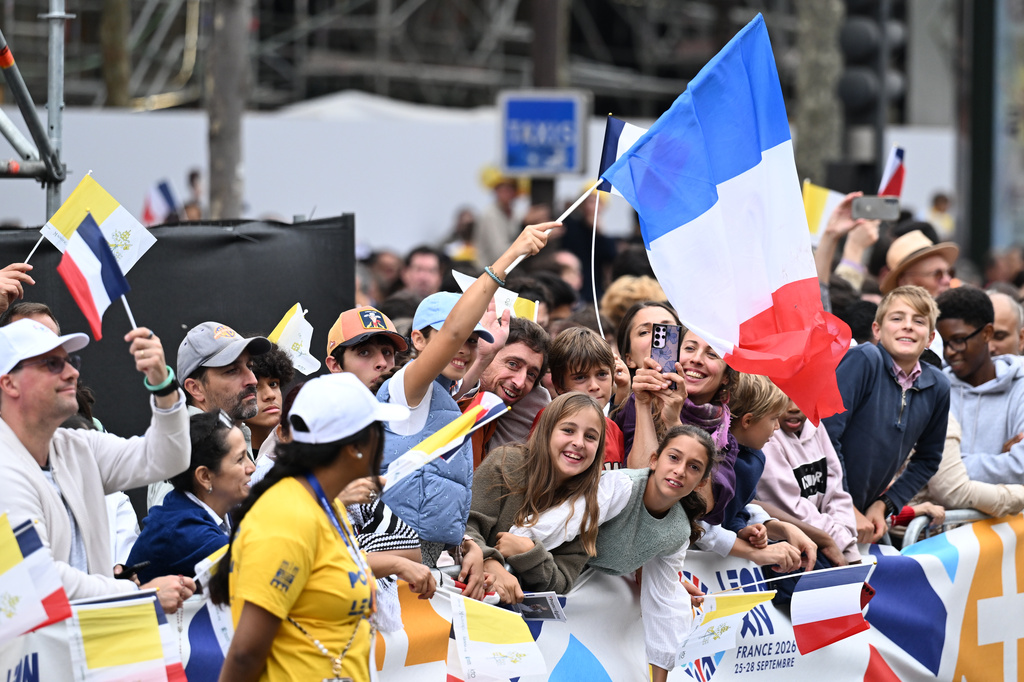 People wait for Pope Leo XIV on the Champs Elysees avenue before a mass at the Place de la Concorde in Paris, Saturday, Sept. 26, 2026. (AP Photo/Emma Da Silva)