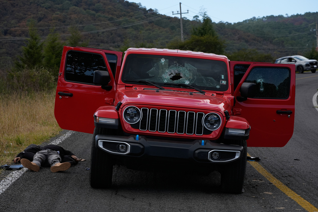 A body lies beside a bullet-riddled vehicle in Tapalpa, Mexico, Monday, Feb. 23, 2026, a day after the Mexican army killed Jalisco New Generation Cartel leader Nemesio Oseguera Cervantes, known as "El Mencho." (AP Photo/Marco Ugarte)