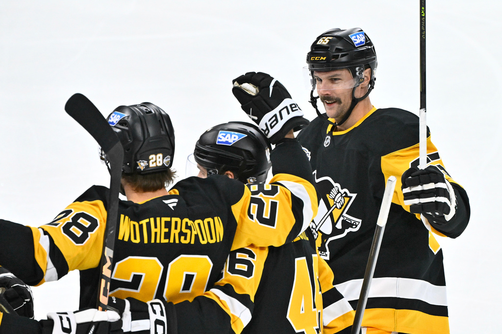 Pittsburgh's Parker Wotherspoon is congratulated by teammates Blake Lizotte and Erik Karlsson after his 1-0 goal during the NHL Global Series hockey game between the Pittsburgh Penguins and the Nashville Predators in Stockholm, Sweden, Sunday, Nov. 16, 2025. (Claudio Bresciani/TT News Agency via AP)
