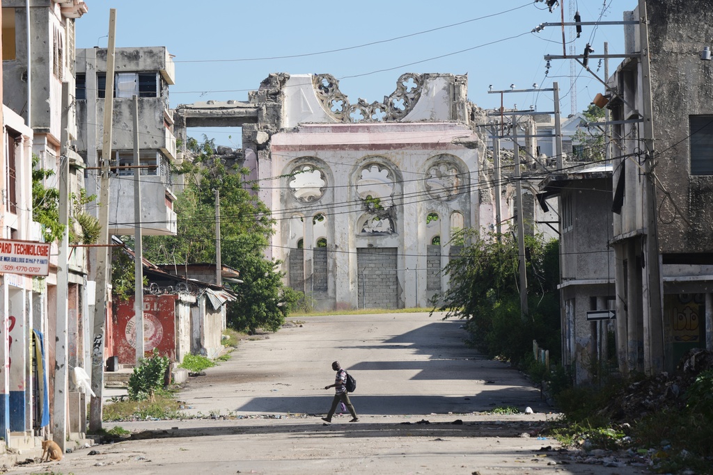 A man walks along a deserted street where a part of the earthquake-destroyed Cathedral stands in downtown Port-au-Prince, Haiti, Monday, March 16, 2026. (AP Photo/Odelyn Joseph)