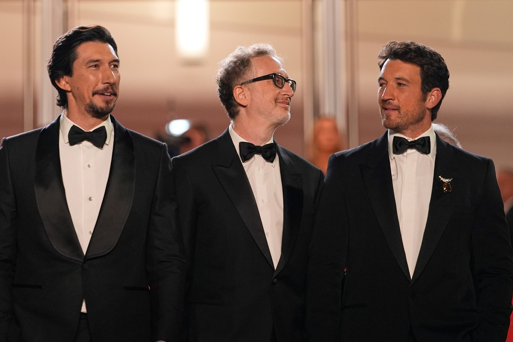 Adam Driver, left, director James Gray and Miles Teller pose for photographers upon arrival at the premiere of the film 'Paper Tiger' at the 79th international film festival, Cannes, southern France, Saturday, May 16, 2026. (AP Photo/John Locher)