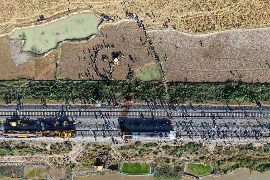 An excavator dig a pit to burry the carcass an Asiatic wild elephant being removed from a railway track after a speeding train hit a heard of wild elephant in the early morning in Changjurai village east of Guwahati, India, Saturday, Dec. 20, 2025. (AP Photo/Anupam Nath)