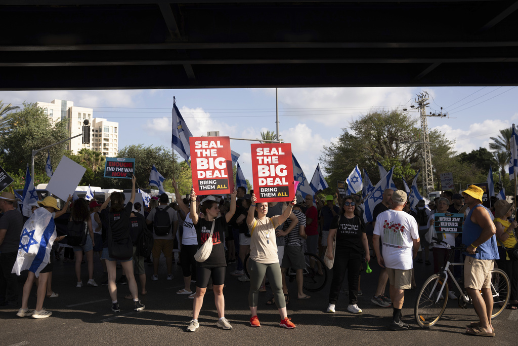 Demonstrators block a road during a protest demanding the immediate release of hostages held by Hamas and calling for the Israeli government to reverse its decision to take over Gaza City and other areas in the Gaza Strip, in Tel Aviv, Israel, Sunday, Aug. 17, 2025. (AP Photo/Maya Levin)
