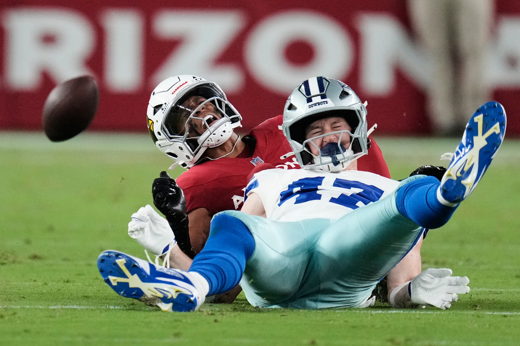 Dallas Cowboys tight end Zack Kuntz (47) takes a hit from Arizona Cardinals safety Dadrion Taylor-Demerson, rear, in the first half of a preseason NFL football game Saturday, Aug. 22, 2026, in Glendale, Ariz. (AP Photo/Ross D. Franklin)