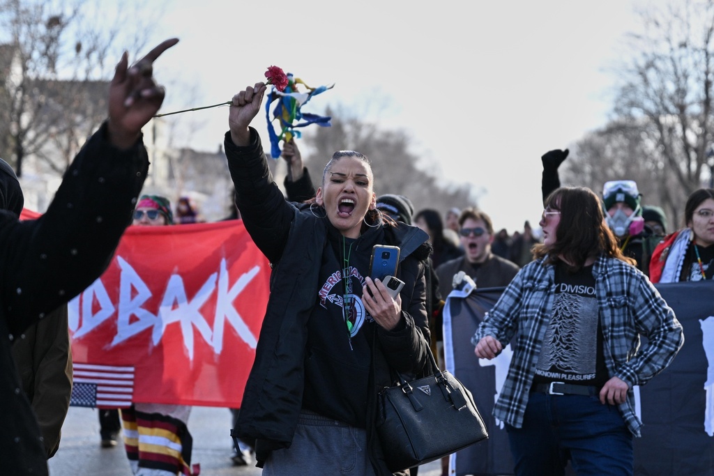 People protest as law enforcement officers attend to the scene of the shooting involving federal law enforcement agents, Wednesday, Jan. 7, 2026, in Minneapolis. (AP Photo/Tom Baker)