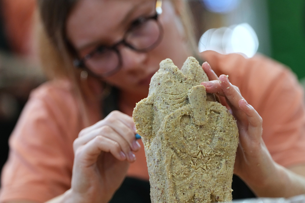 Victoria Roath works on her creation in the Scrapple Sculpting Contest at the Reading Terminal Market in Philadelphia, Friday, Oct. 10, 2025. (AP Photo/Matt Rourke)