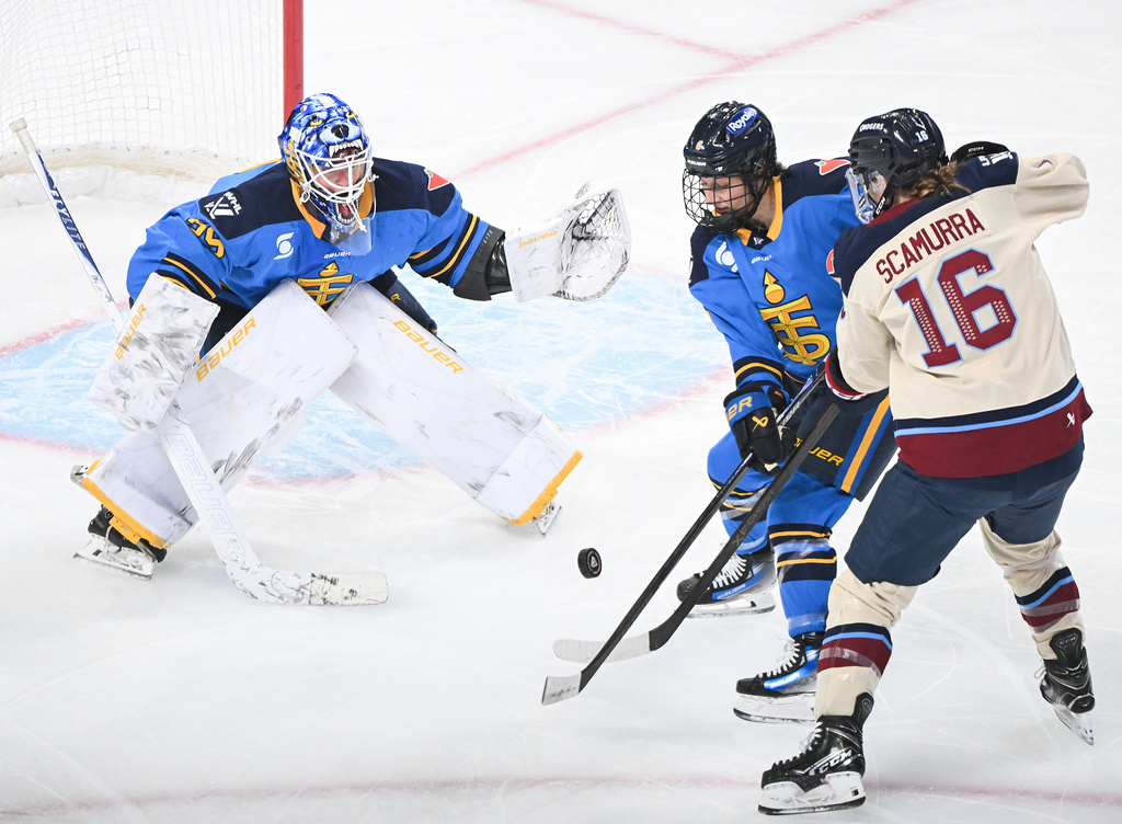 Toronto Sceptres' Kali Flanagan, center, defends against Montreal Victoire's Hayley Scamurra (16) as she moves in on Sceptres goaltender Elaine Chuli (29) during the first period of a PWHL hockey game in Montreal, Saturday, Dec. 27, 2025. (Graham Hughes/The Canadian Press via AP)