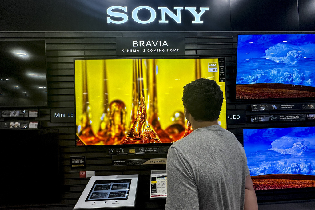 A man views a new television at a store in Kennesaw, Ga., on Thursday, Aug. 14, 2025. (AP Photo/Mike Stewart)