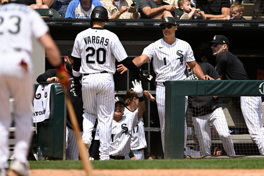 Chicago White Sox's Miguel Vargus (20) celebrates with manager Will Venable (1) at the dugout after scoring on Edgar Quero's sacrifice fly in the first inning of a baseball against the Detroit Tigers in Chicago, Saturday, May 30, 2026. (AP Photo/Paul Beaty)