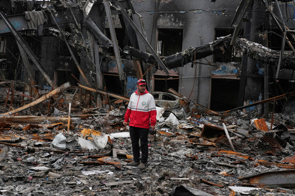 A member of the Iranian Red Crescent Society stands at Hypercar, an auto service center, amid damages which according to the company's officials were caused by strikes on March 1, in Tehran, Iran, Saturday, March 28, 2026. (AP Photo/Vahid Salemi)