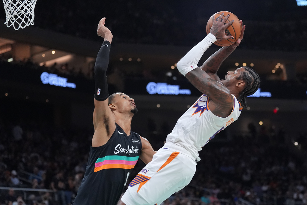 Phoenix Suns guard Jalen Green, right, shoots against San Antonio Spurs forward Victor Wembanyama (1) during the first half of an NBA basketball game in Austin, Texas, Thursday, Feb. 19, 2026. (AP Photo/Eric Gay)