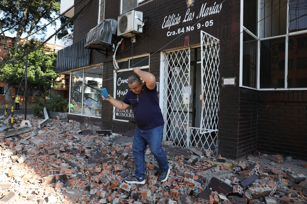 A man leaves an apartment building after an earthquake struck Cali, Colombia, Monday, Aug. 10, 2026. (AP Photo/Santiago Saldarriaga)