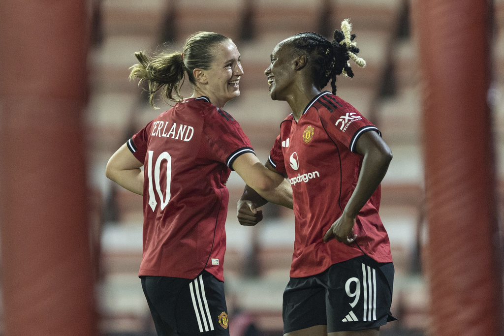 Manchester United's scorer Elisabeth Terland, left, and her teammate Melvine Malard, right, celebrate their side's third goal during the women's Champions League third qualifying round, second leg, soccer match between Manchester United and Brann in Leigh, England, Thursday, Sept. 18, 2025. (Barrington Coombs/PA via AP)