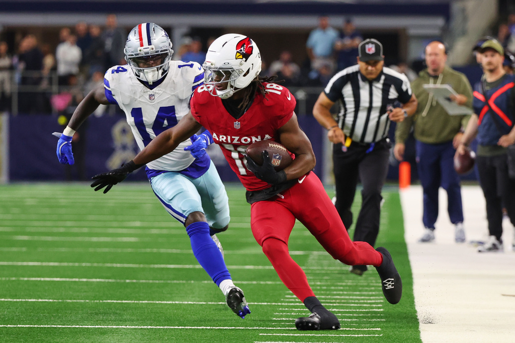 Arizona Cardinals wide receiver Marvin Harrison Jr. (18) gains yards after catching a pass as Dallas Cowboys safety Markquese Bell (14) gives chase in the second half of an NFL football game Monday, Nov. 3, 2025, in Arlington, Texas. (AP Photo/Richard Rodriguez)