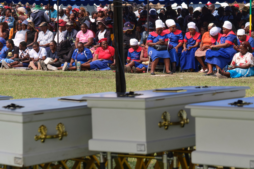 Mourners gather for a memorial service for the victims of a ferry that capsized on Lake Kariba in Kariba, Zimbabwe, Thursday, Aug. 13, 2026. (AP Photo/Mkhululi Thobela)