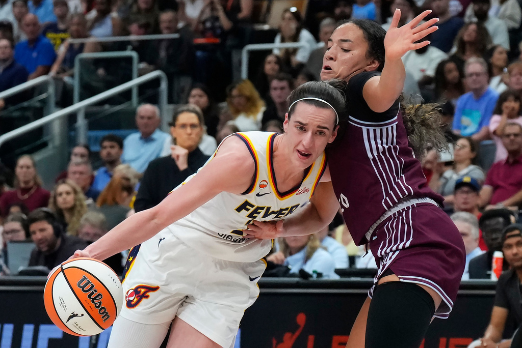 Indiana Fever's Caitlin Clark (22) drives past Toronto Tempo's Kiki Rice (1) during the first half of a WNBA basketball game in Toronto on Tuesday, Aug. 18, 2026. (Chris Young/The Canadian Press via AP)