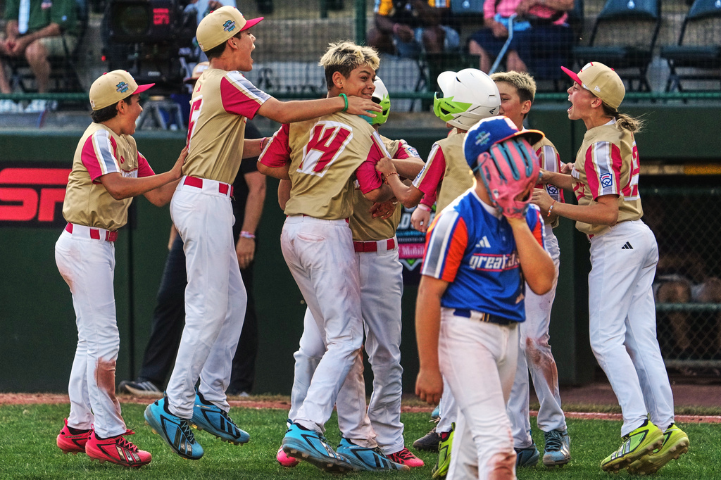 Henderson, Nev.'s Maddox Brian (14) celebrates with teammates after driving in the game-winning run off Hamilton, Ohio's Leo Feltner, foreground right, during the fifth inning of the United States Championship baseball game at the Little League World Series tournament in South Williamsport, Pa., Saturday, Aug. 29, 2026. (AP Photo/Gene J. Puskar)
