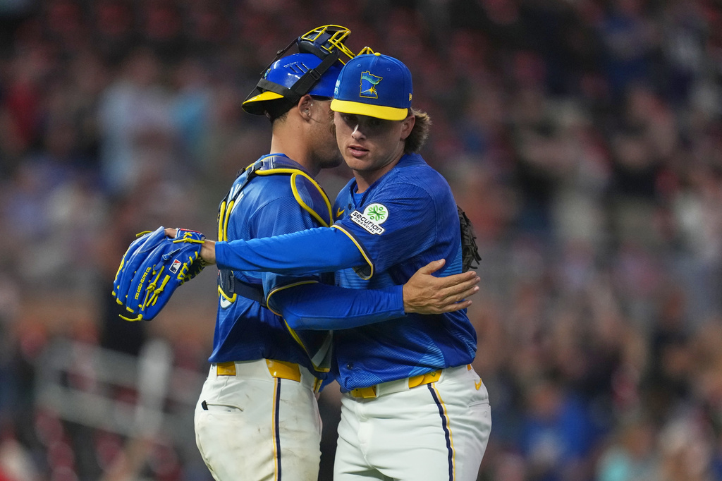 Minnesota Twins catcher Alex Jackson, left, and relief pitcher Travis Adams, right, hug after a baseball game against the Kansas City Royals, Friday, June 5, 2026, in Minneapolis. (AP Photo/Abbie Parr)