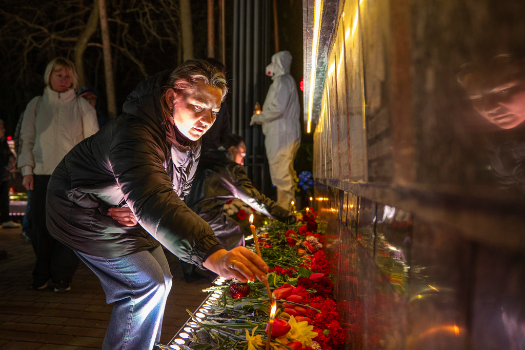 A man lights a candle at a memorial dedicated to firefighters and workers who died after the 1986 Chornobyl (Chernobyl) nuclear disaster, ahead of its 40th anniversary in Slavutych, Ukraine, Saturday, April 25, 2026. Chornobyl is the Ukrainian name for the city. (AP Photo/Dan Bashakov)