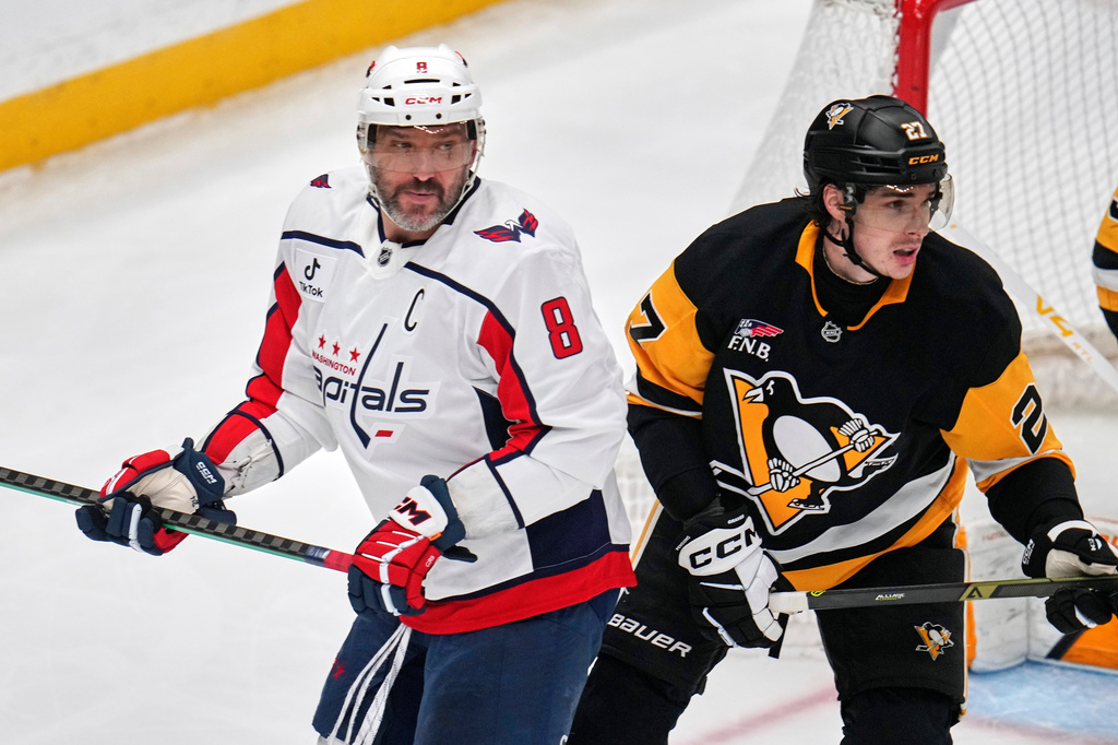 Washington Capitals' Alex Ovechkin (8) is defended by Pittsburgh Penguins' Ryan Graves (27) during the first period of an NHL hockey game in Pittsburgh, Saturday, April 11, 2026. (AP Photo/Gene J. Puskar)