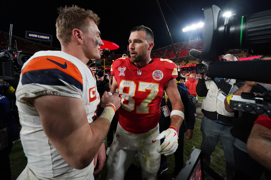 Denver Broncos quarterback Bo Nix, left, talks with Kansas City Chiefs tight end Travis Kelce following an NFL football game Thursday, Dec. 25, 2025, in Kansas City. (AP Photo/Ed Zurga)