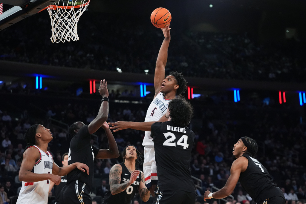UConn's Tarris Reed Jr. (5) shoots over Xavier's Jovan Milicevic (24) during first half of an NCAA college basketball game in the quarterfinals of the Big East basketball tournament Thursday, March 12, 2026, in New York. (AP Photo/Frank Franklin II)