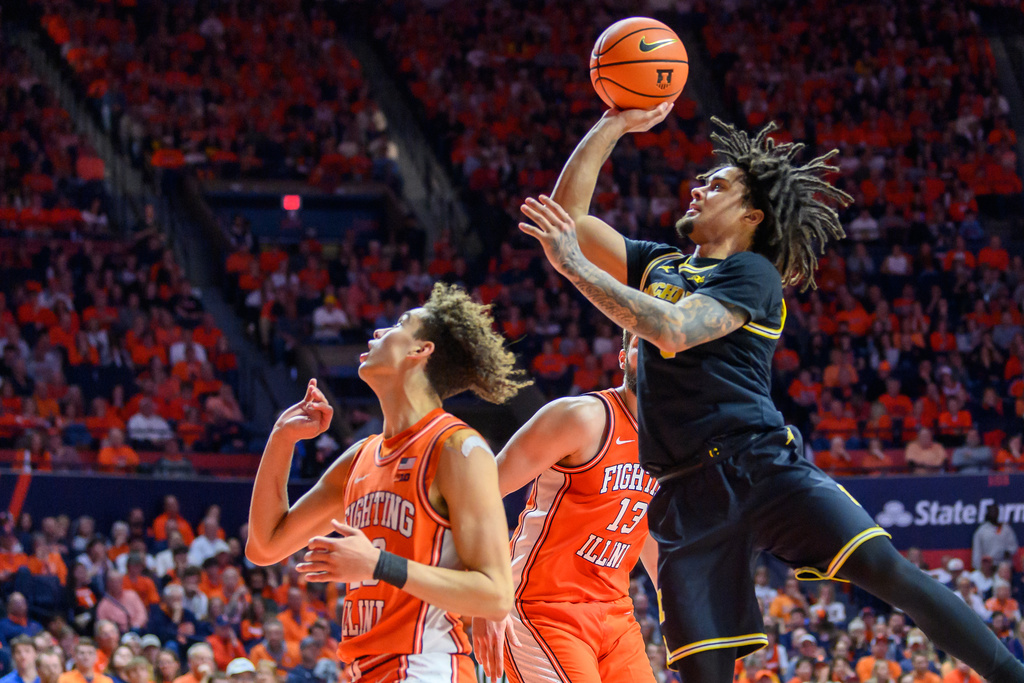 Michigan's Elliot Cadeau, right. goes up to the basket over Illinois' Keaton Wagler, left, during the second half of an NCAA college basketball game Friday, Feb. 27, 2026, in Champaign, Ill. (AP Photo/Craig Pessman)
