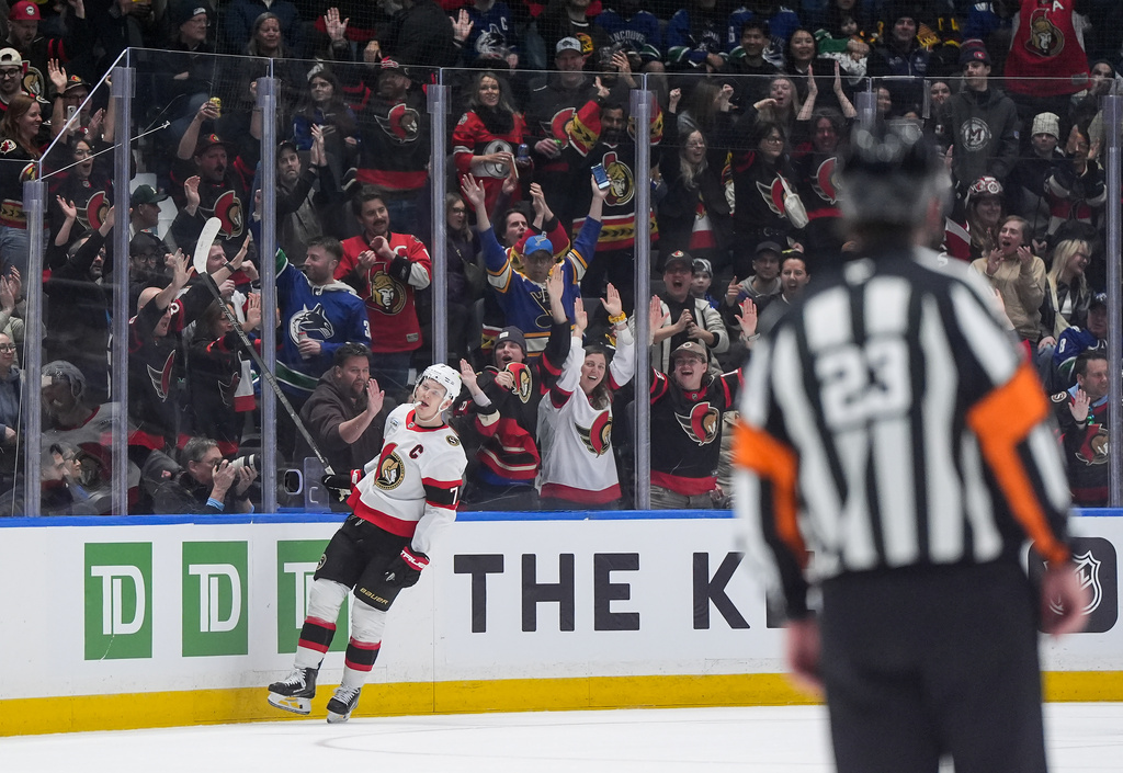 Fans celebrate Ottawa Senators' Brady Tkachuk's empty net goal against the Vancouver Canucks during the third period of an NHL hockey game, in Vancouver, on Monday, March 9, 2026. (Darryl Dyck/The Canadian Press via AP)