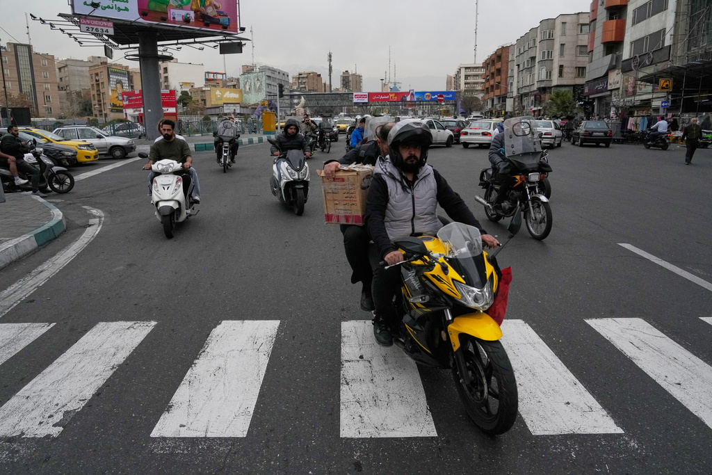People drive their motorbikes in a square in downtown Tehran, Iran, Tuesday, Feb. 24, 2026. (AP Photo/Vahid Salemi)