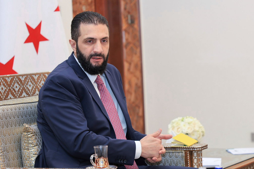 FILE - In this photo released by the Syrian official news agency SANA, Syria's interim President Ahmad al-Sharaa receives the final version of the provisional electoral system for the People's Assembly, in Damascus, Syria, Sunday, July 27, 2025. (SANA via AP, file)